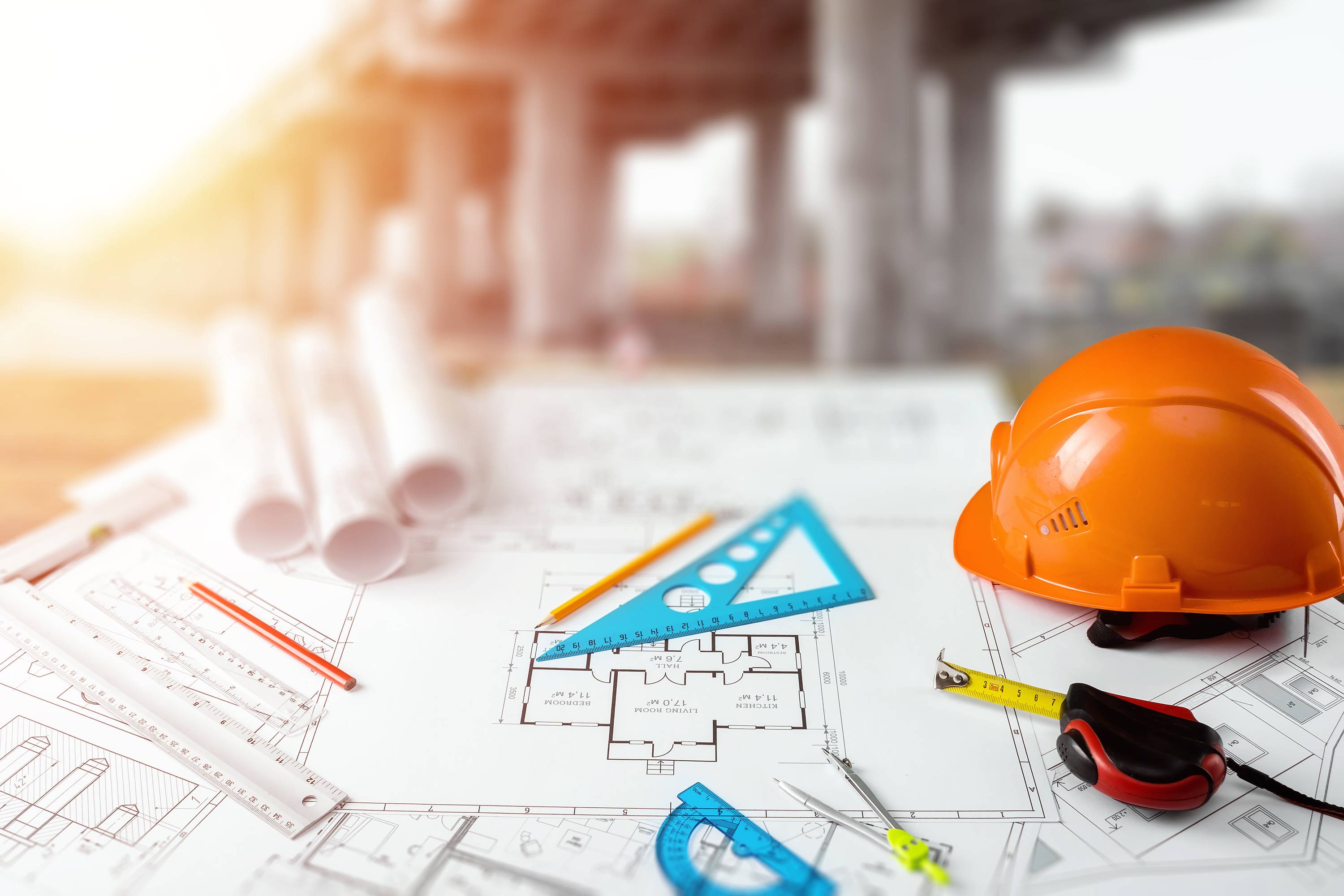 Orange helmet, pencil, architectural construction drawings, tape measure. The concept of architecture, construction, engineering, design. Copy space.